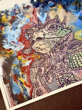 A photograph of a mixed-media painting on paper featuring a stylized horned creature with intricate patterned details, set against a chaotic background of blue, red, and yellow brushstrokes.