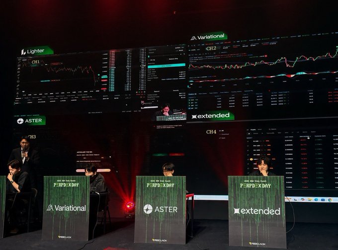 A 'PERP EX DAY' trading competition event shows three competitors at podiums for Variational, ASTER, and extended platforms, with large screens displaying cryptocurrency charts above them.