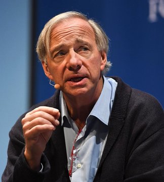 Ray Dalio, founder of Bridgewater Associates, speaks into a headset microphone while gesturing with his hand, illustrating his recent remarks about Bitcoin potentially benefiting from growing government debt and currency depreciation.