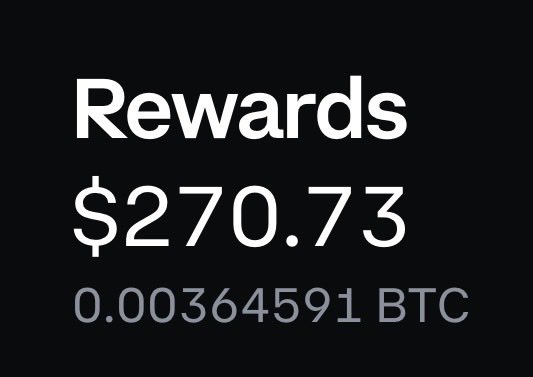 The image features a black background with white text that reads "REWARDS $27,769,733 0.0383636454951 BTC". The text is written in a blocky font style, which makes it stand out against the black background. The text also includes numbers and symbols related to cryptocurrency transactions or rewards.