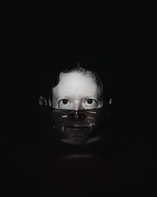 A dark, shadowy portrait of a person whose face is partially obscured and distorted, resembling the 'Gollum face' meme.