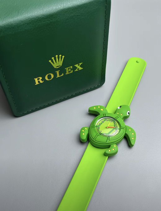 A green turtle-shaped Rolex watch with a bright green strap displayed next to its green Rolex-branded case.