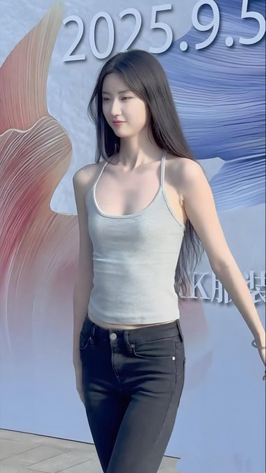 A woman with long dark hair wearing a white tank top and dark jeans stands in front of a backdrop displaying the date '2025.9.5'.