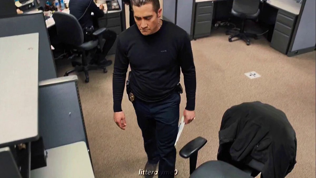 The image shows a man walking through an office space with several desks and chairs around him. The man appears to be dressed in a police uniform, indicating that he might be a cop or working in law enforcement. In the background of the image, there is text that reads "SELL YOUR #XRP. GO ON, SELL IT. THIS WILL BE YOU SOON... LIVING WITH THE BIGGEST REGRET OF YOUR LIFE." This message seems to be related to Bitcoin and cryptocurrency, possibly suggesting a promotion or an advertisement for these digital assets.