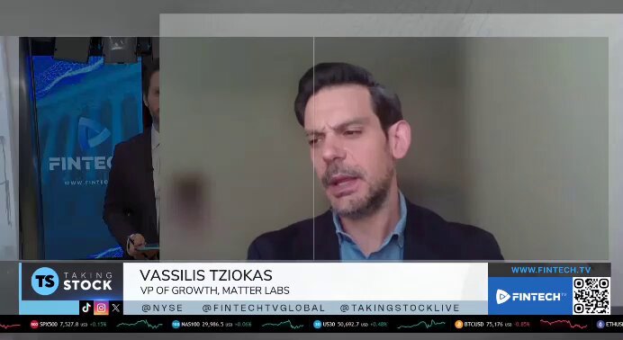 The image shows a man wearing a suit talking into a microphone, with a large screen behind him displaying a video of him speaking. The background of the screen features a blue banner that says "FinanceTech" and "ZKsync". There is also a text box on the screen that reads "@TziokasV the VP of Growth from @the_matter labs talking about @ZKsync at the @NYSE is bigger than people realize. Prividium is probably one of the most important pieces here).