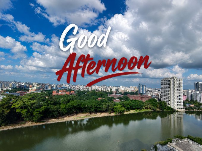 An aerial cityscape view of a lake bordered by trees and high-rise buildings under a cloudy blue sky, overlaid with the stylized text 'Good Afternoon' in white and red script.