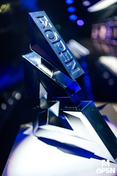 A metallic trophy with the 'A7-OPEN' branding, photographed in blue lighting on display.