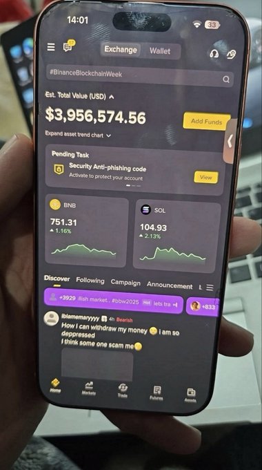 Binance app displayed on a smartphone, showing estimated total value of $3,956,574.56 and BNB and SOL holdings; a security anti-phishing-code task is visible.