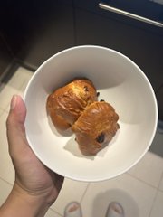 A hand holds a white bowl containing two golden-brown muffins or pastries, presented as visual evidence to substantiate the accompanying claim. The image serves as "proof" to accompany the post, though the specific subject of disbelief being addressed is not visible beyond the baked goods themselves.