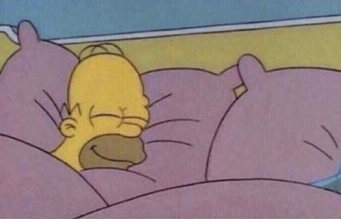 A still from The Simpsons showing baby Maggie sleeping peacefully with her pacifier in bed under pink covers.