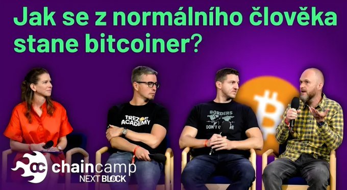 Four people sit on a stage during a 'chaincamp NEXT BLOCK' panel discussion, with Czech text above asking 'Jak se z normálního člověka stane bitcoiner?' (How does a normal person become a bitcoiner?), alongside a Bitcoin logo.