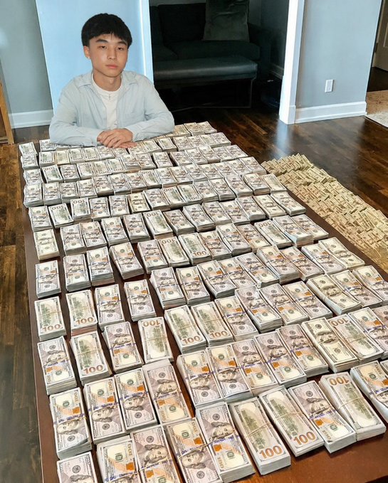 A young man sits behind a massive display of $100 bills and banded currency stacks, showcasing apparent wealth in a staged "money on the table" photo. The image ties to the post's narrative of meme coins like $ZBCNS as a "new asset class," using the visual flex to promote the Pumpfun/Phantom-based crypto as the next path from internet culture to capital.