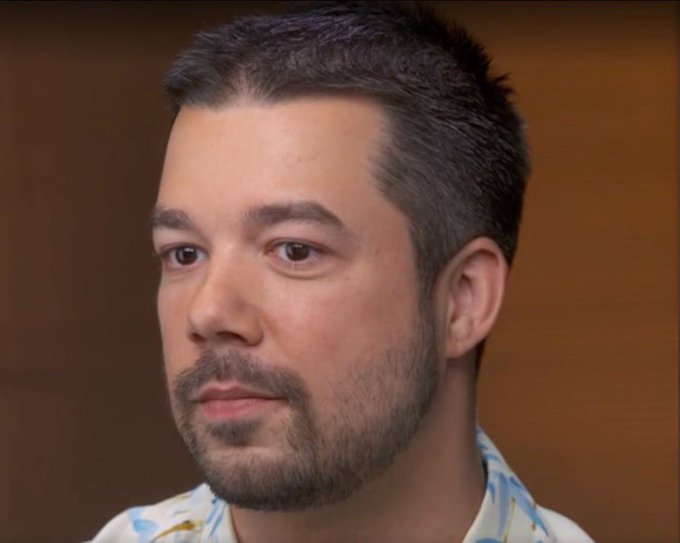A close-up photo of a dark-haired, bearded man in a patterned shirt appears in a video still, likely depicting one of the early Bitcoin pioneers referenced in the caption about GPU mining discovery and the early Bitcoin pizza incident era.