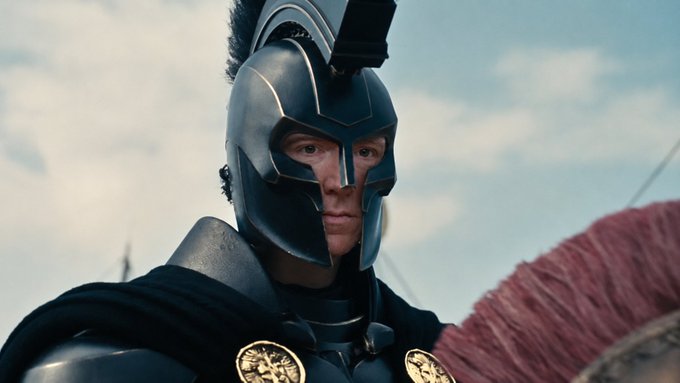 A close-up shot of a character wearing an ornate dark helmet with a crest, appearing to be from a historical or fantasy film.