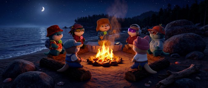 A 3D animated scene depicts several anthropomorphic animal characters wearing hats and goggles, gathered around a campfire on a rocky beach at night under a crescent moon.