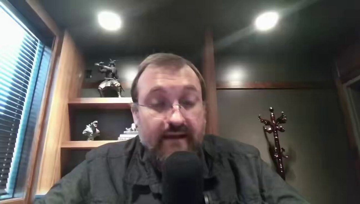 The image shows an older man wearing glasses sitting at a desk with a microphone in front of him. He appears to be talking into the microphone during a video call or recording session, possibly discussing the importance of regulatory clarity for crypto startups. The focus on this topic highlights the need for companies operating within the cryptocurrency space to adapt and comply with new regulations as they arise.