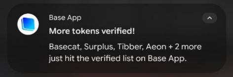A Base App alert titled "More tokens verified!" announces that $BASECAT, Surplus, Tibber, Aeon and others have been added to the verified list, directly celebrating $BASECAT's inclusion in the notification.