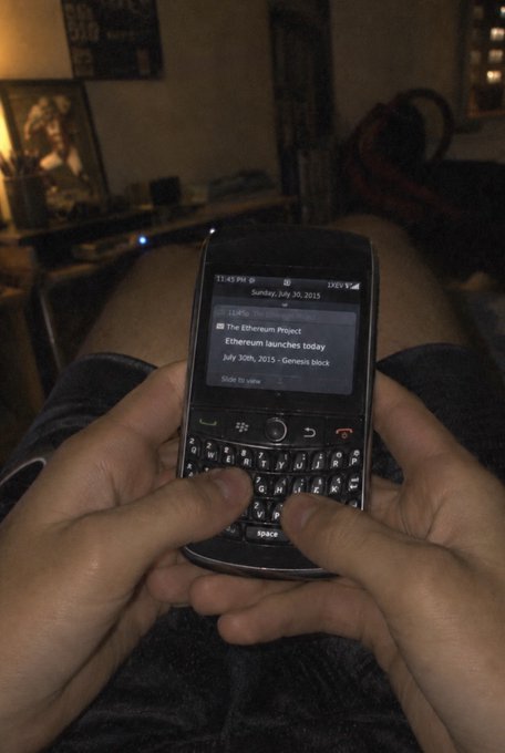 A person holds a BlackBerry phone displaying a notification for "The Ethereum Project" and its launch on July 30th, 2015, illustrating the poster's sentiment of being unaware of $ETH's creation in 2015.