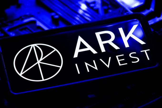 An illuminated ARK Invest logo sign featuring the company's circular emblem on a circuit board with blue lighting.