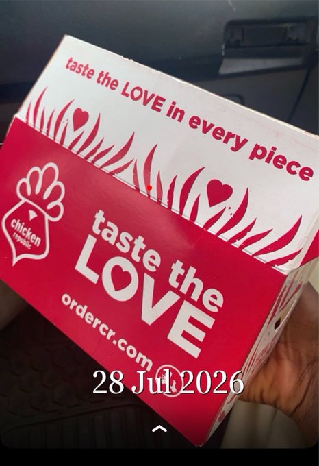 A hand holds a red and white cardboard food box from "Chicken Republic" with the text "taste the LOVE in every piece" and "taste the LOVE" printed on it, along with "order.cr.com" and a date stamp reading "28 Jul 2026".