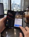 A person holds a smartphone displaying a trading app with a candlestick chart for Bitcoin (BTC) and "FUTUREMODE" branding, set against a Hong Kong skyline backdrop. The image visually reinforces the post's theme of learning crypto trading locally rather than buying an "iPhone Duo," highlighting the Bitcoin chart being discussed with Edward.
