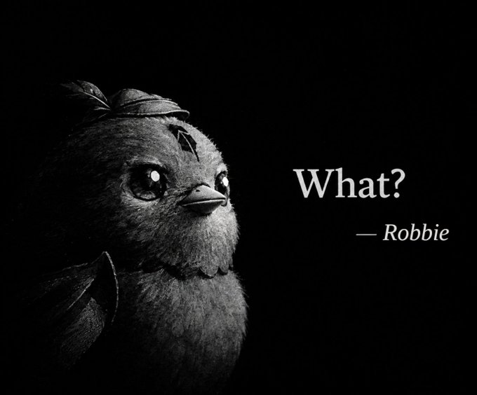 A black and white image of a fuzzy bird character with a small hat, accompanied by the text 'What?' and '— Robbie' in white serif font on a black background.