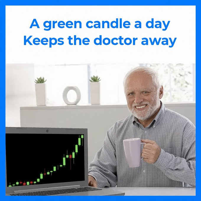 A smiling older man with a gray beard sits at a desk holding a mug, beside a laptop displaying a green candlestick stock chart trending upward. The text reads "A green candle a day Keeps the doctor away," playfully flipping the classic apple proverb to suggest that bullish green trading candles bring health benefits, countering the post's sentiment about red candles causing sickness.