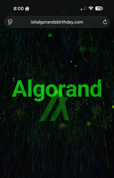 The image shows a phone screen with an advertisement for Algorand. The background of the ad features green grass, and there are fireworks depicted in the center of the image. The text "Happy Birthday, #Algorand MainNet! 7 years of non-stop Algorand since June 12, 2019 I got @d13_co 's animated #AlgorandBirthday #NFT" is displayed on the screen. This post seems to be related to a birthday celebration for Algorand or an event involving the company's mainnet.