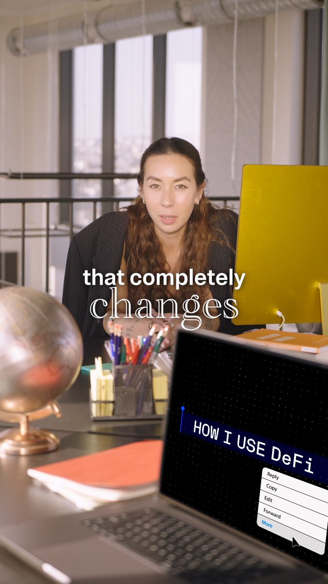 The image features a woman sitting at a desk with an open laptop computer. The laptop screen displays text that reads "How I use DFi". In addition to the laptop, there are several other items on the desk such as a globe, pens, pencils, and books. A keyboard is also present in front of the laptop.