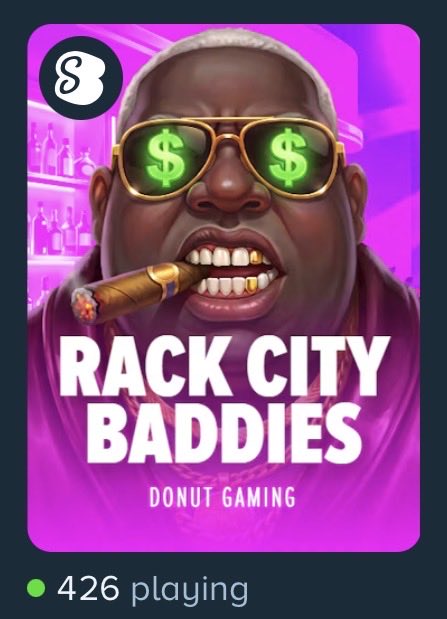 The image is a promotional graphic for the live game "RACK CITY BADDIES" by Donut Gaming on Stake, featuring a stylized illustration of a man with dollar sign sunglasses and a cigar, and displays "426 playing" as the current player count.