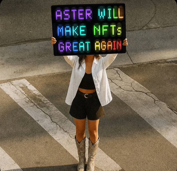 The image features a woman standing in front of a sign that reads "ASTER will make NFT great again!". The woman is holding up the sign, which has colorful letters and numbers written on it. She appears to be wearing cowboy boots and a white blouse. The background shows a street with a sidewalk running alongside it.
