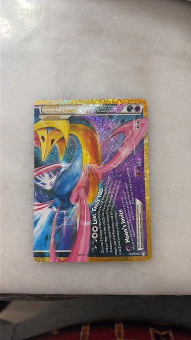 A holographic gold-bordered Pokémon card featuring Milotic is displayed on a white textured surface, with visible attack text reading "Lost City 100" and "Moon's Invite." The image relates to the post by showcasing an impressive card pull that likely excited the poster, though the angle obscures the exact card number and set details.