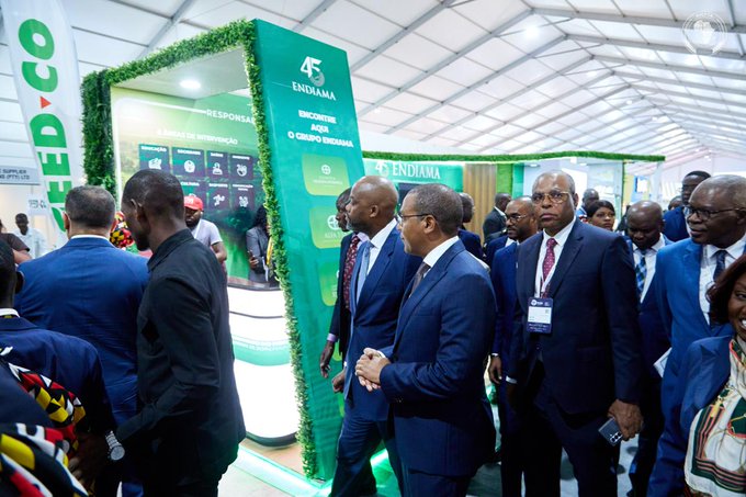 A group of people in business attire gathered at an event with a green "45 ENDIAMA" booth and "MOCUBEX CO" signage visible in the background.