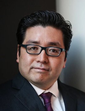 A professional headshot of Tom Lee, the Fundstrat strategist behind BitMine, wearing glasses, a dark suit, and a purple tie. The image accompanies news that his BitMine venture has acquired 27,084 ETH valued at $43 million.