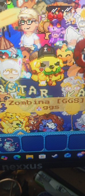 A close-up of a computer monitor displaying a pixel-art game scene featuring a dog wearing a firefighter helmet labeled '1,' with 'KANSTAR' and 'Zombina [GGS]' text visible.