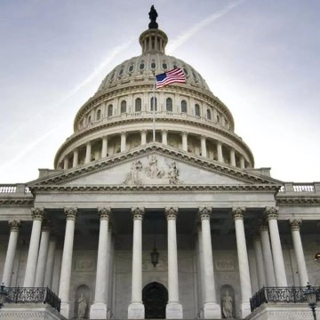 The U.S. Capitol building is shown with the American flag flying atop its iconic white dome and neoclassical columns framing the entrance. The image visually reinforces the post's focus on federal legislative action, representing the Washington, D.C. setting where the CLARITY Act is being championed by the White House Crypto Council this "critical week."