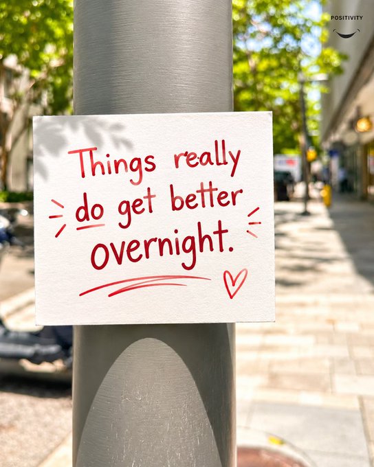 A handwritten note on a street pole reads 'Things really do get better overnight' with a small heart drawing.