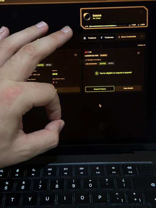 A close-up of a hand making a gesture in front of a laptop displaying the Lucid trading platform, showing a 'LUCIDFLEX SOL' funded evaluation account with $646 profit and a 'Request Payout' button.