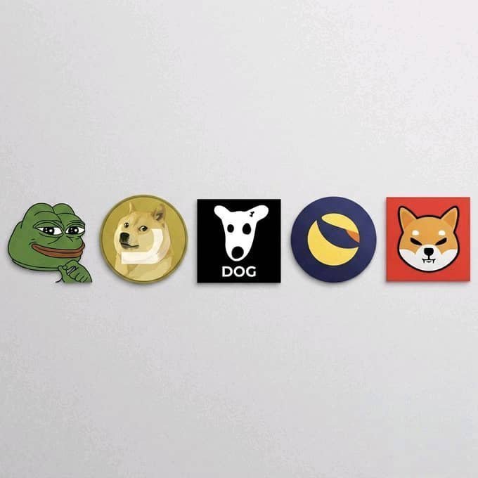Five cryptocurrency logo stickers are displayed in a row on a light gray surface, representing popular meme coins: Pepe the Frog, Dogecoin (gold Shiba Inu), the official DOG logo featuring a Dalmatian-like dog with the text "DOG," the Terra Luna Classic (LUNC) yellow and blue crescent moon logo, and the Shiba Inu coin (red), which visually correspond to the price predictions listed in the accompanying post for $PEPE, $DOGE, $DOG, $LUNC, and $SHIBA respectively.