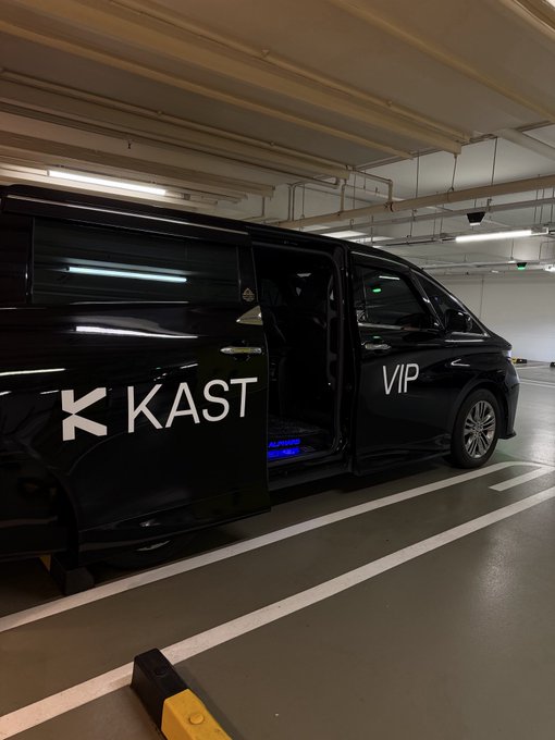 A black KAST luxury shuttle featuring "VIP" lettering waits in a parking garage, its side door open to reveal ambient interior lighting—capturing the premium airport transfer experience promised in the caption about arriving in Singapore.
