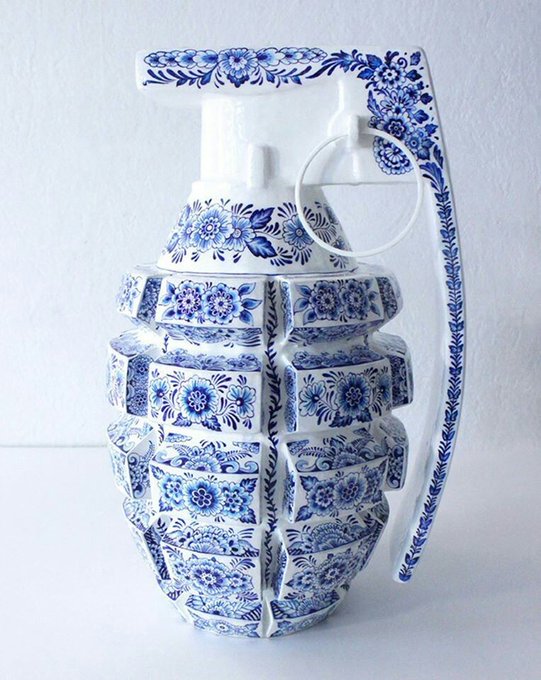 A decorative vase or grenade-shaped sculpture made from white porcelain tiles decorated with traditional blue floral patterns.