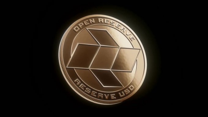 A close-up of a gold-colored coin with a cube-like logo, inscribed with 'OPEN RESERVE' at the top and 'RESERVE USD' at the bottom.