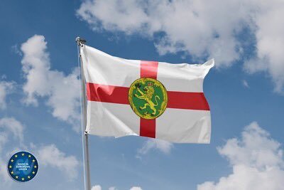 A flag featuring a green dragon emblem on a white background with a red cross waves against a blue sky, while a "Made with AI" badge appears in the corner, visually contrasting the headline's claim that Florida is the first U.S. state to propose eliminating capital gains tax on Bitcoin—using an England-style flag rather than any official Florida imagery.