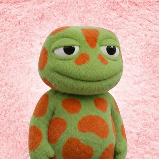 A green cartoon frog plush toy with orange spots stands against a fluffy pink background, giving a sly side-eye glance. The image plays on the "toad" character mentioned in the post about $TOAD reaching 100M market cap and the potential impact on @toadlets_sol's floor price (FP).