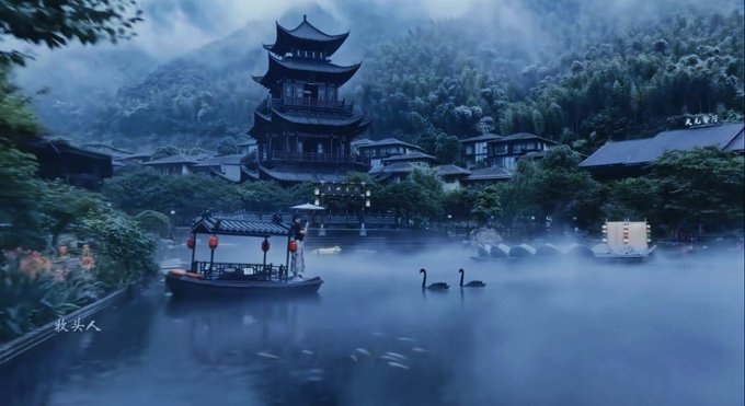 An atmospheric Asian-style digital artwork depicting a traditional Chinese pagoda and village beside a misty lake with swans, a small boat with red lanterns, and mountains shrouded in fog in the background.