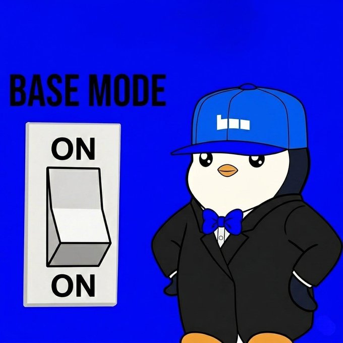 The image features a cartoon penguin standing next to an electric switch with the words "Base mode ON" written above it. The penguin appears to be wearing a suit, hat, and bowtie, giving it a professional appearance. The background of the image is blue, which complements the penguin's attire. The post reads: "Base mode ON. The future is loading." This message suggests that the base mode has been turned on or is about to be turned on, indicating an upcoming event or task in the cartoon penguin's life.