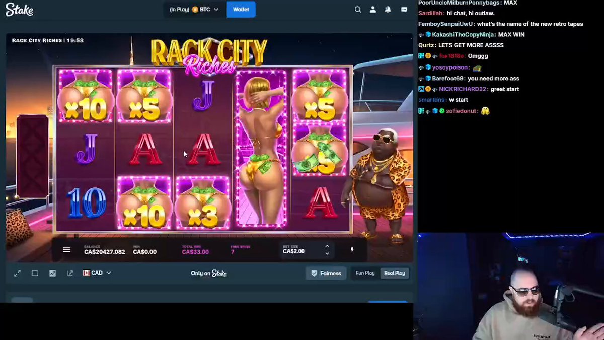 The image shows a man sitting at a slot machine with a game interface displayed on his computer screen. The game appears to be a slot machine or video game, possibly a casino game like "Rack 'n' Cheyenne". The man is wearing glasses and seems to be engaged in playing the game. There are several buttons visible on the screen that could be used for gameplay, such as the "J" button, which might represent a jackpot or a specific action within the game.