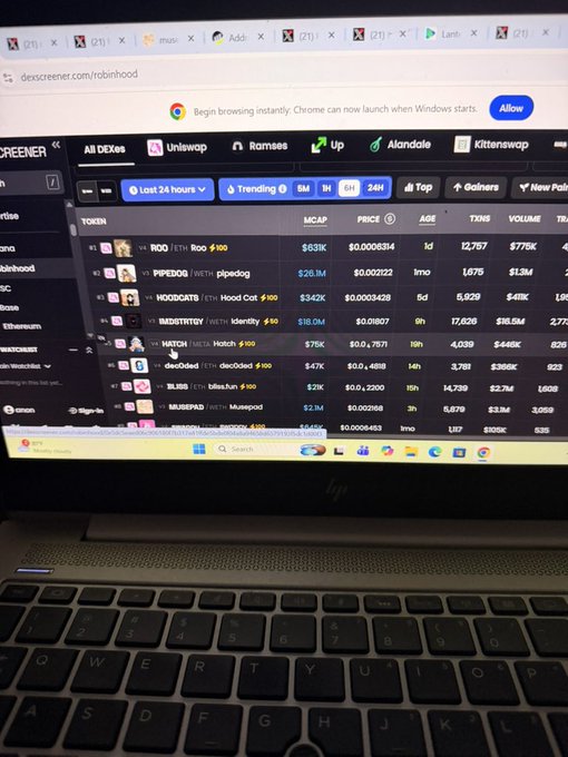 An HP laptop screen displays the DEX Screener website on dexscreener.com/robinhood, showing a list of cryptocurrency tokens including RIO, PEPE2.0, HOODOGS, BADKITTY, HATCH, dec0dec0, BLISS, and MUBSDOG with their market caps and prices.