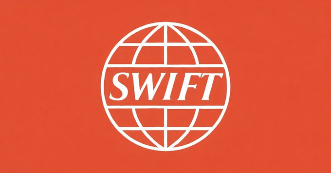 The image shows the SWIFT logo—a white globe with the word "SWIFT" across its center—set against a red-orange background, directly representing the financial messaging network mentioned in the post as adopting the new ISO 20022 standard for 90% of international transactions.