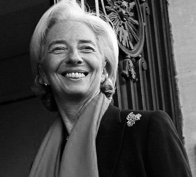 The image shows a smiling older woman with short white hair, wearing a dark coat with a light scarf and a decorative pin, posing in front of an ornate metal gate. The black-and-white portrait does not depict any text, numbers, or tickers, but it may relate to the post as a promotional image of a person connected to the "Pontes Digital Euro" event from September 12–21.